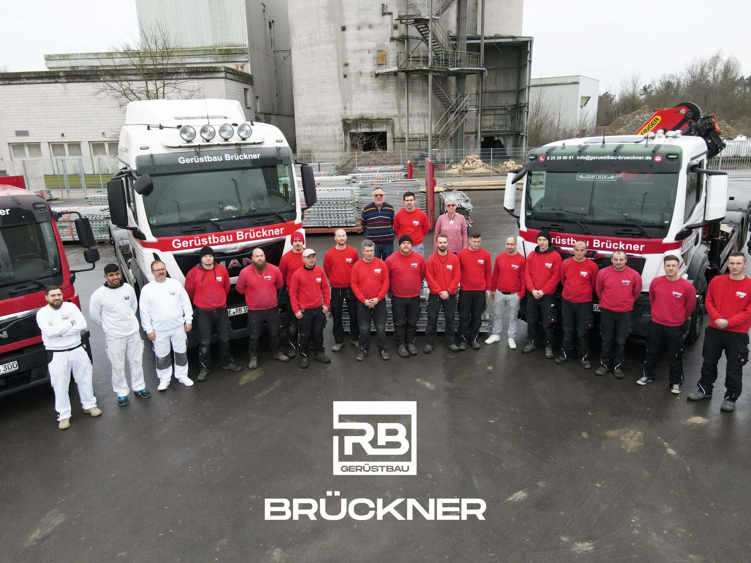 Geruestbau Brueckner Teamfoto mit LKWs